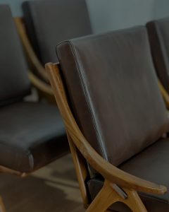 Kursi lounge kayu jati model retro dengan bantalan kulit cokelat untuk ruang tamu dan cafe