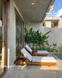 Kursi santai kolam renang kayu jati dengan bantalan putih di area outdoor modern
